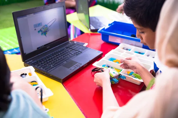 A younger student programming a robotics project