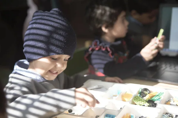 A young learner concentrating on a robotics activity
