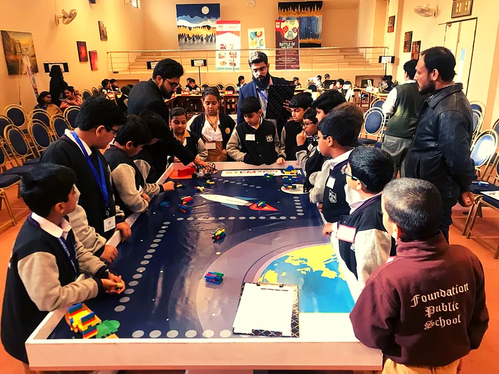 Students gathered around a robotics field during the Inter-school STEM Olympiad